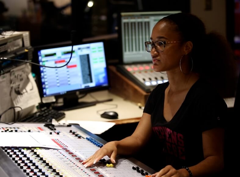 A female producer working at a mixing desk