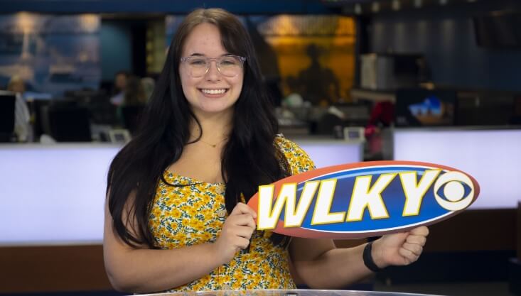 Morgan Gonzalez holding a WLKY sign in a TV studio