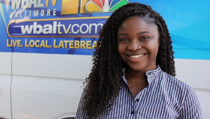 Kellina Djanfa Wanteu standing next to a WBAL TV van